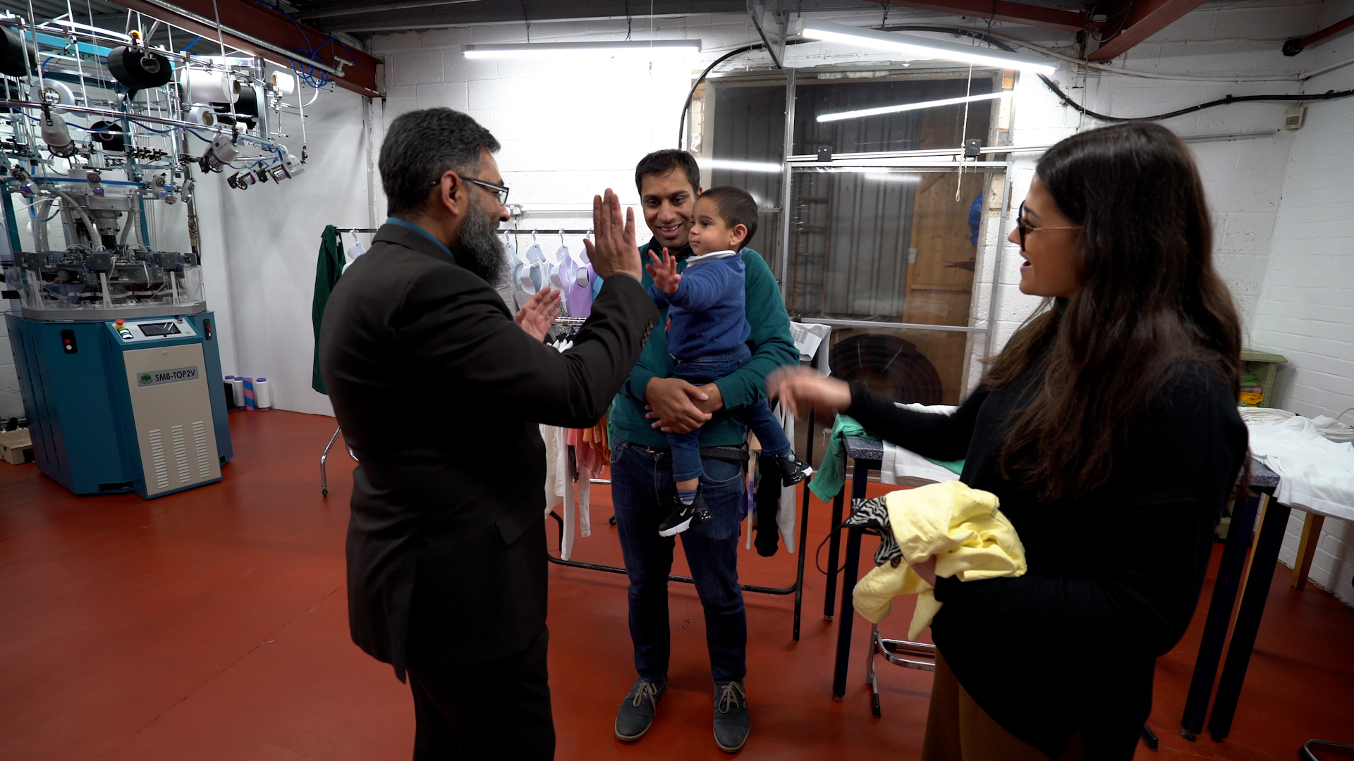Three people and child in factory setting