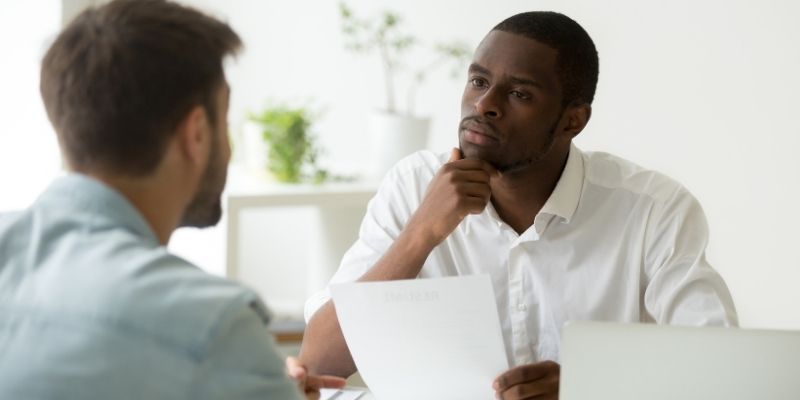Two men looking at each other in a meeting