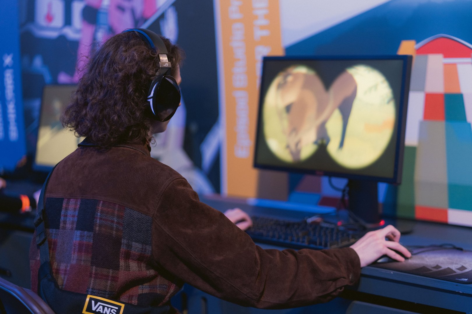 person with headphones looking at gaming screen