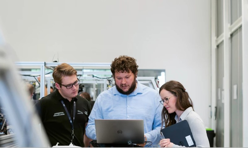 three people looking at lap top