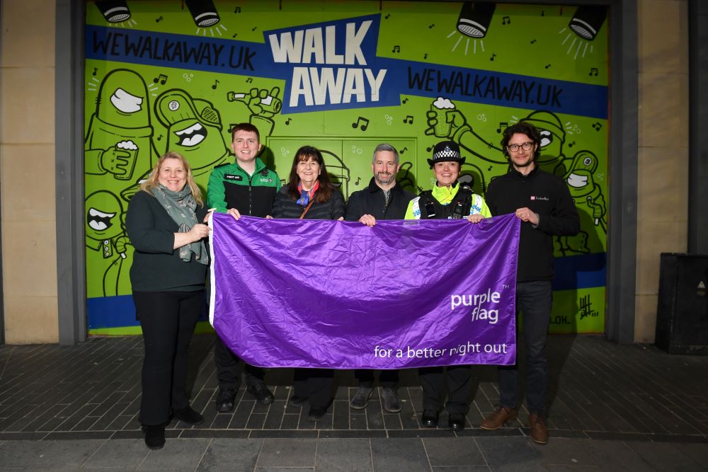 people holding a purple flag