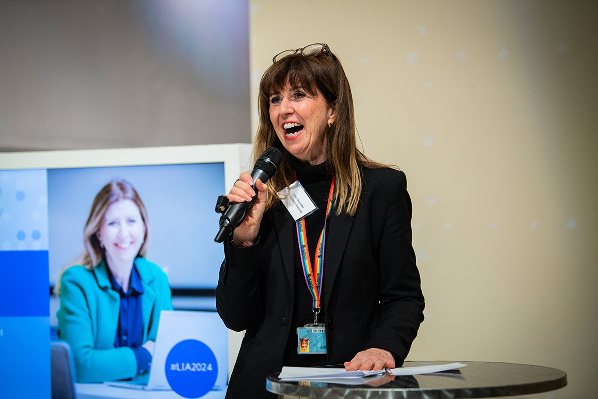 Woman with dark hair holding a mic