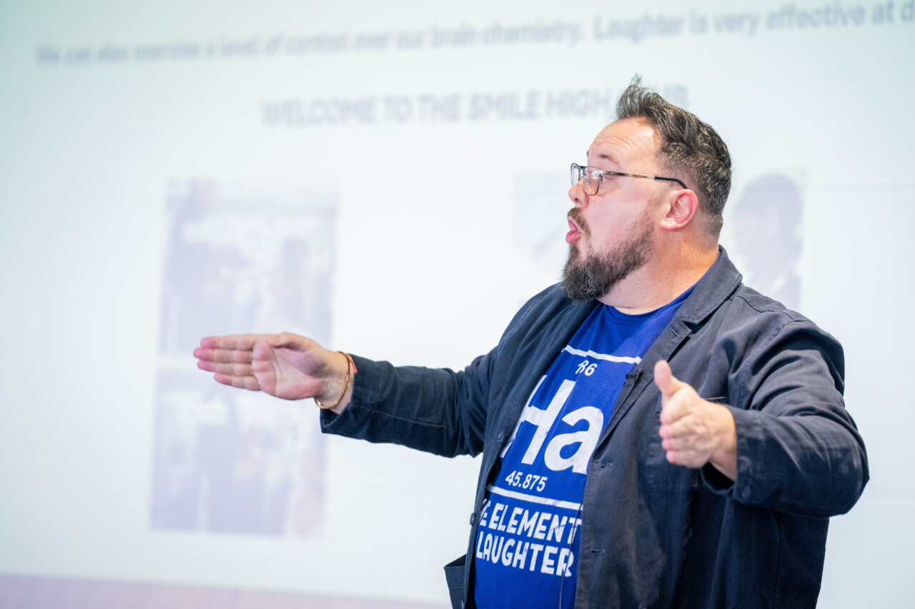 man with beard with arms wide talking