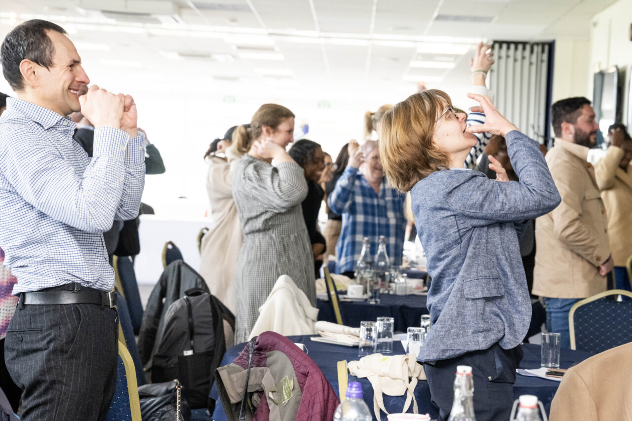 audience at an event standing up laughing